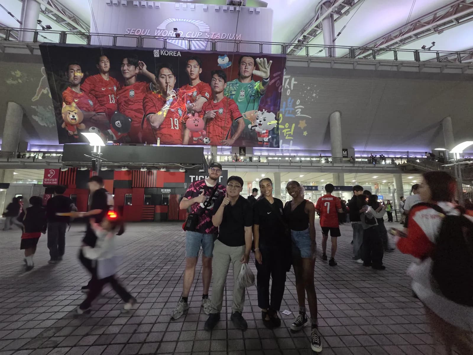 Guests and their buddy meeting under the national team mural at Seoul World Cup Stadium