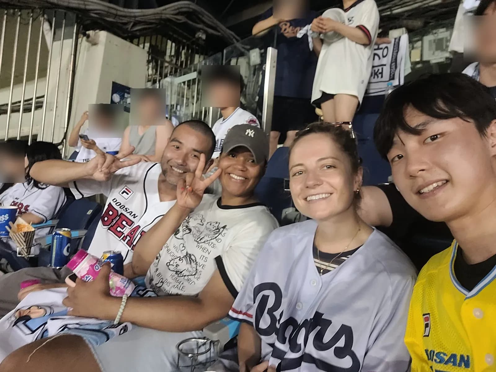 Travelers and local buddies cheering together at a baseball game