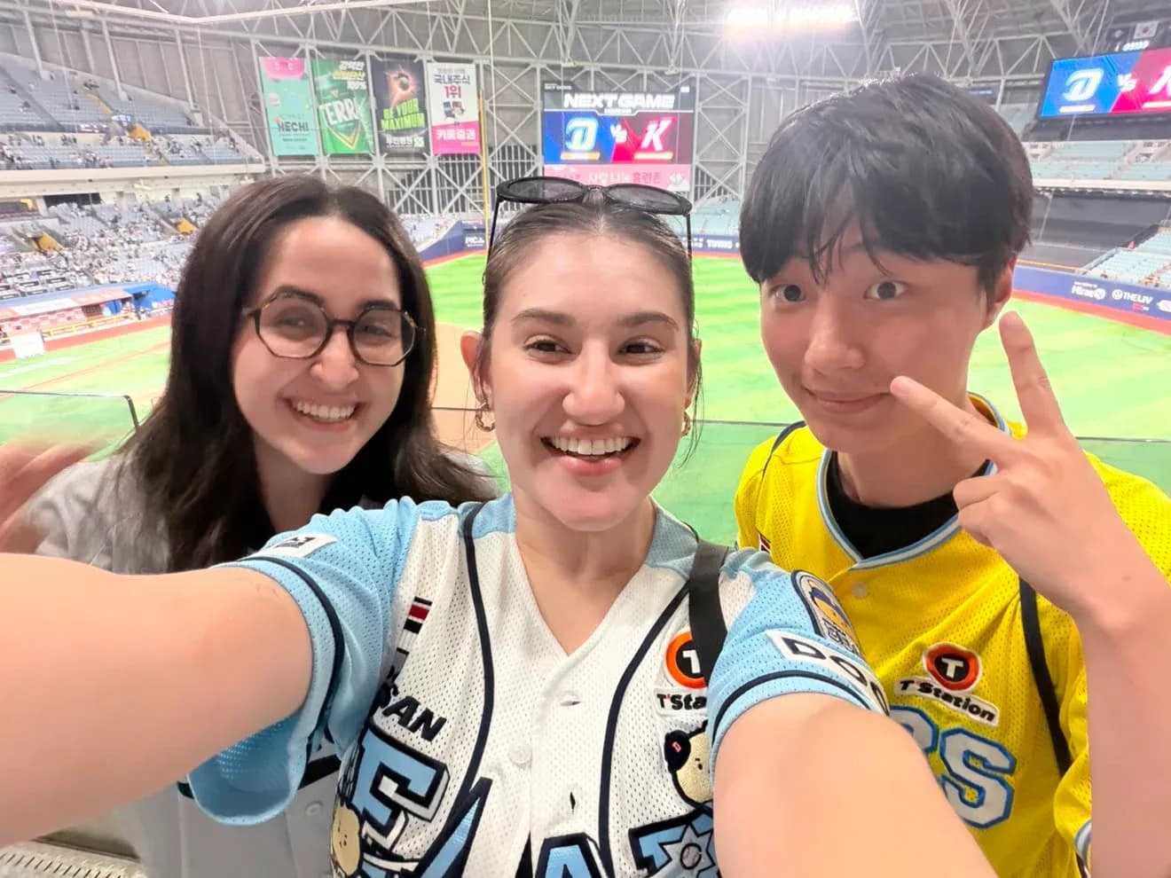 Three friends smiling in the stands at Gocheok Sky Dome