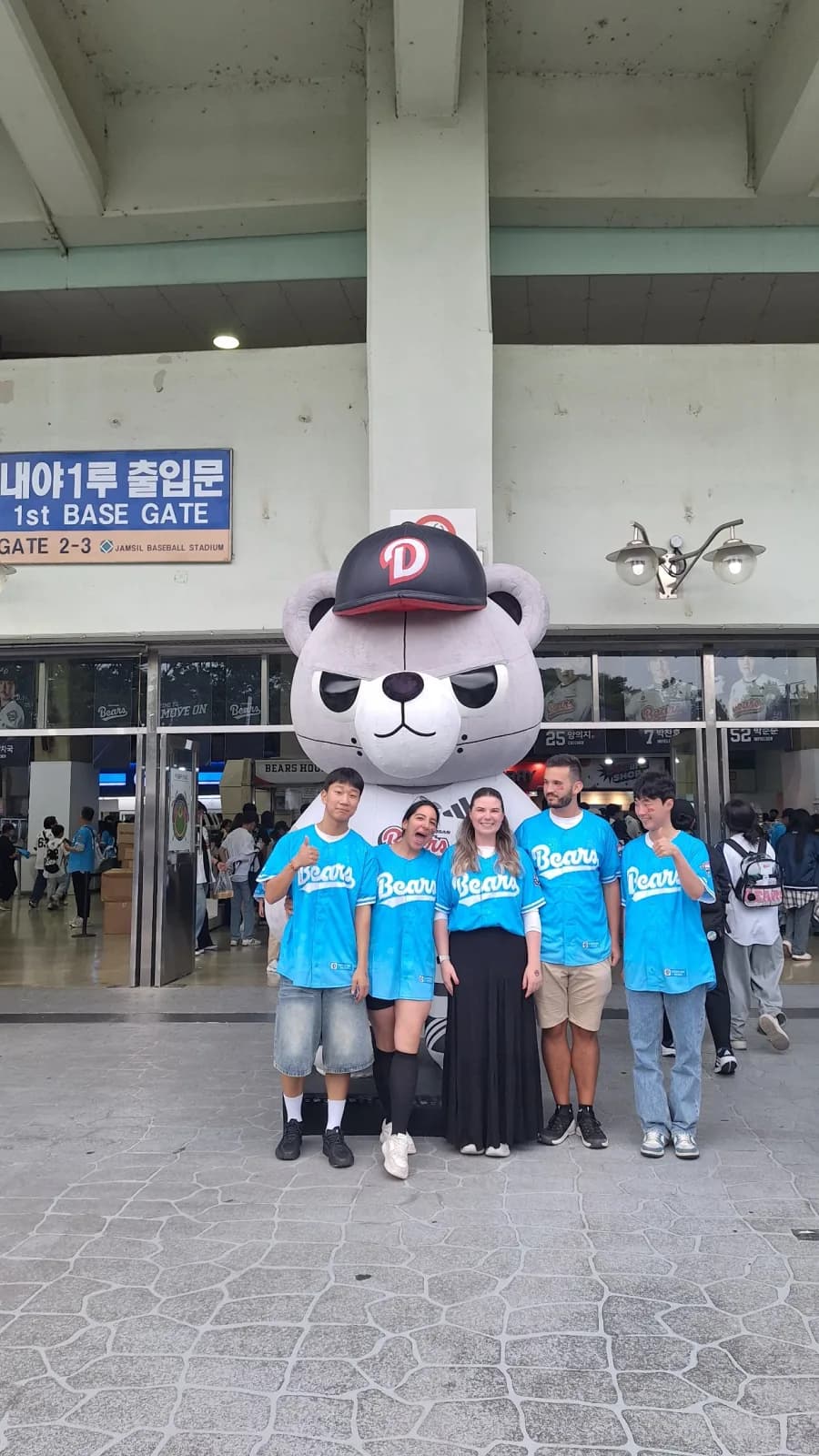 Guests and buddies posing with the Doosan Bears mascot at Jamsil Stadium