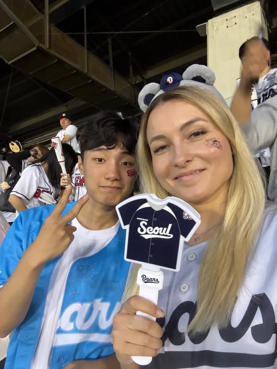 A guest and a buddy wearing bear-ear headbands in the Jamsil stands
